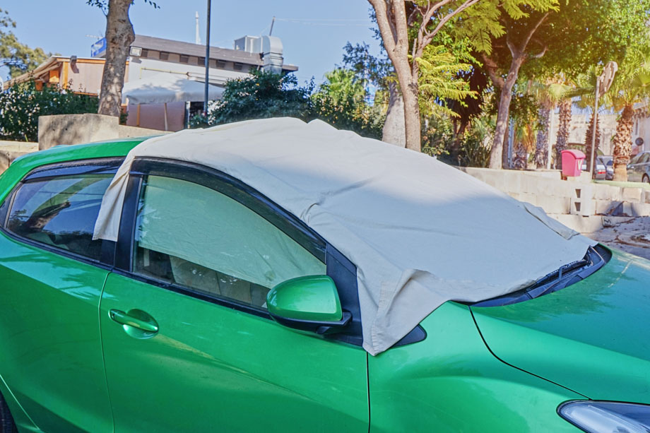 Εξωτερική, ηλιοπροστασία αυτοκινήτου, χρώματος γκρι. Καλύπτει το παρμπρίζ πράσινου αμαξιού.